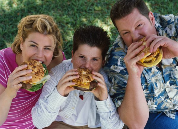 Overweight family eating hamburgers